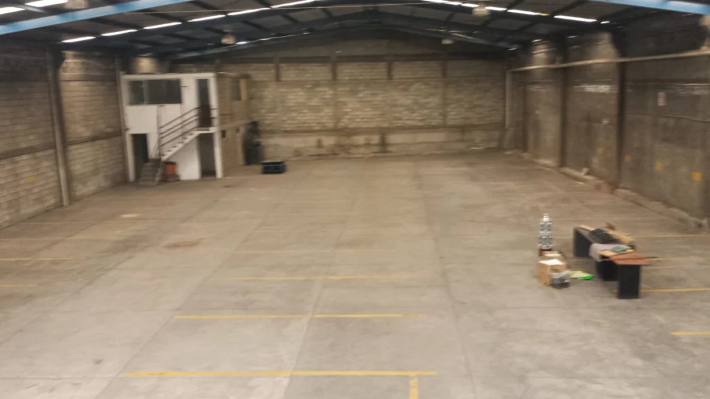 Nave industrial vacía con piso de uso rudo, lista para operar